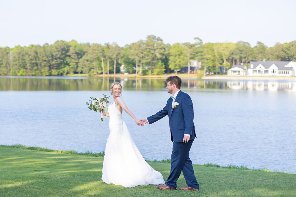 Bride and groom walking by a lake