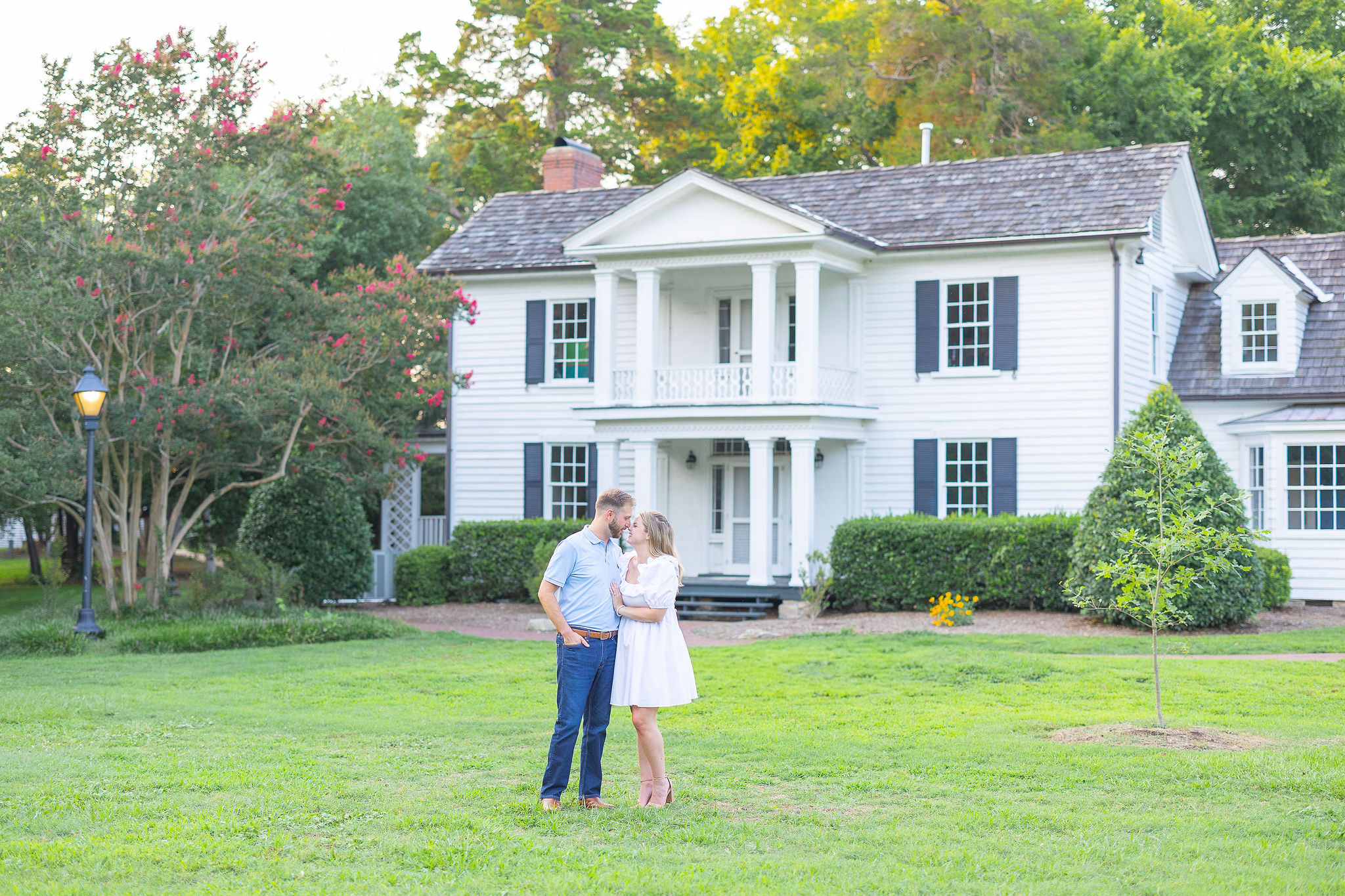 Couple in field outside white house