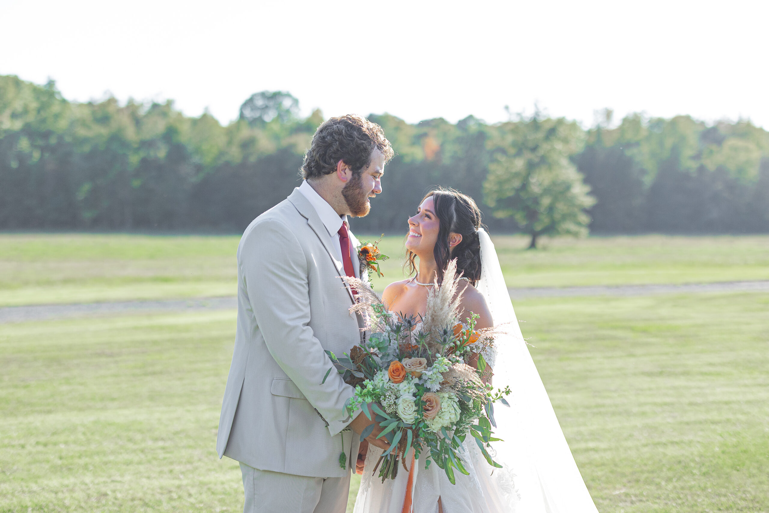 Bride and Groom on field with bouquet