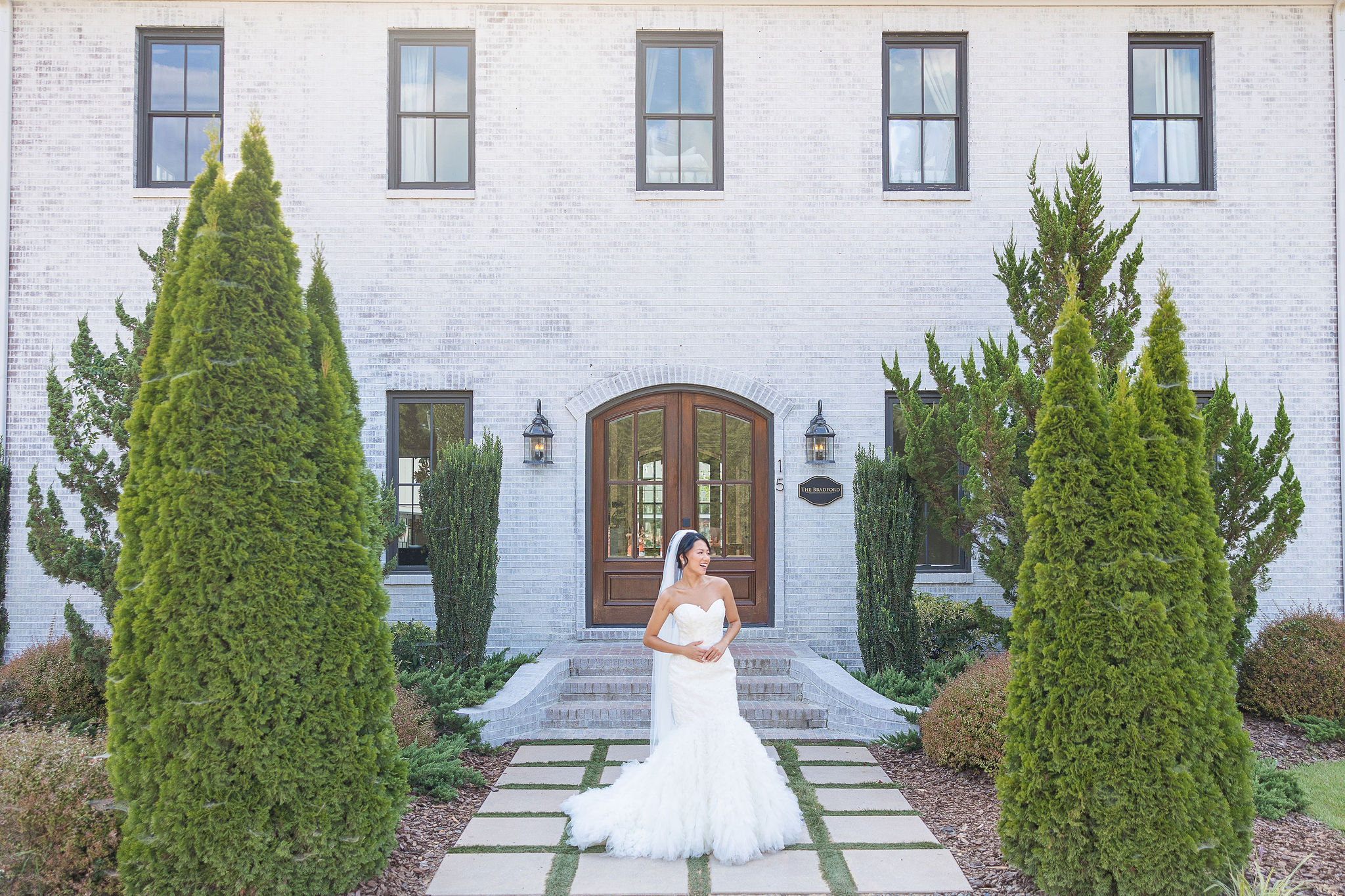 Bride outside of venue in wedding gown and veil