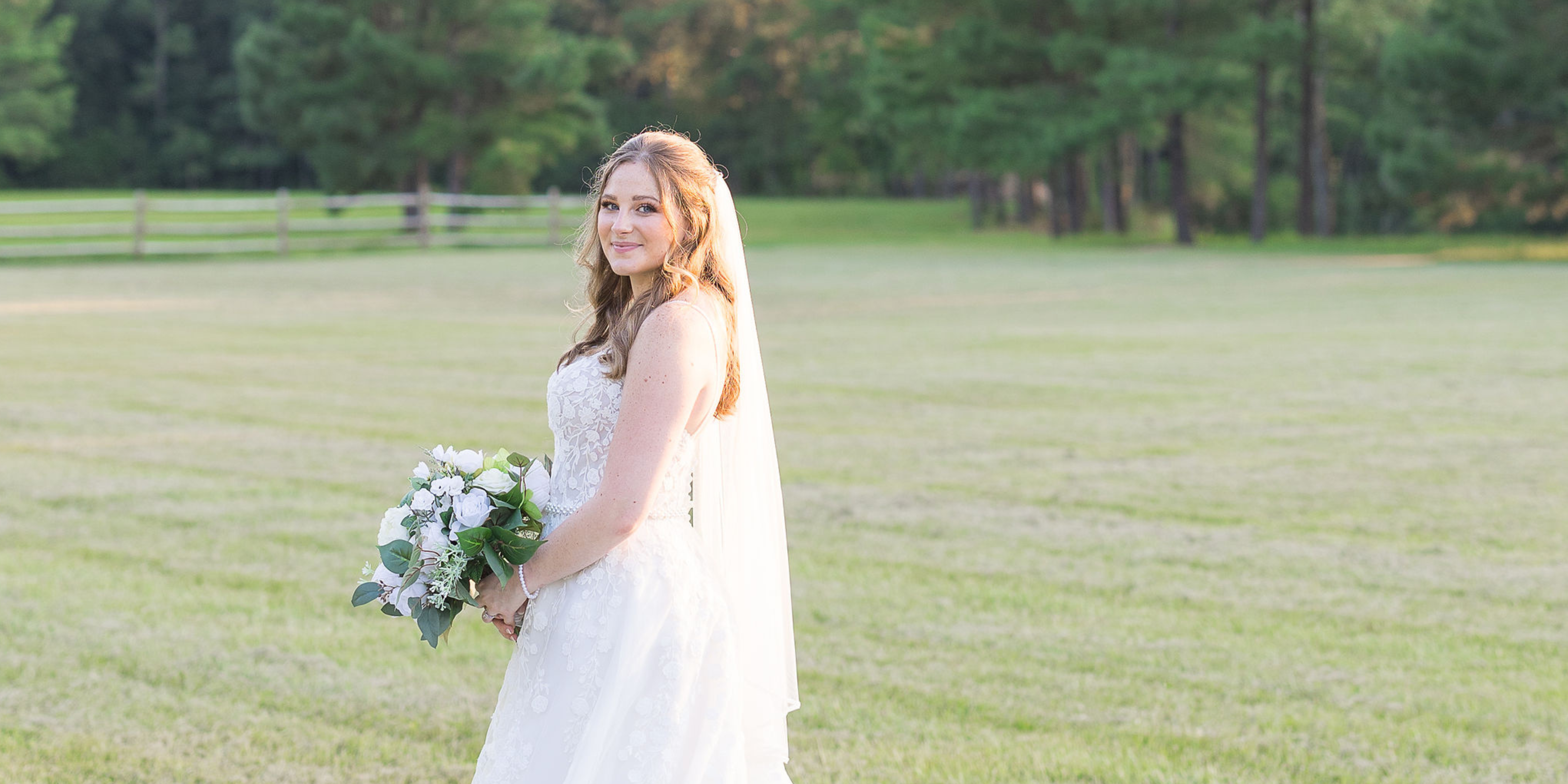 Sunset Bridal Portrait with bride holding bouquet of flowers and wearing a veil