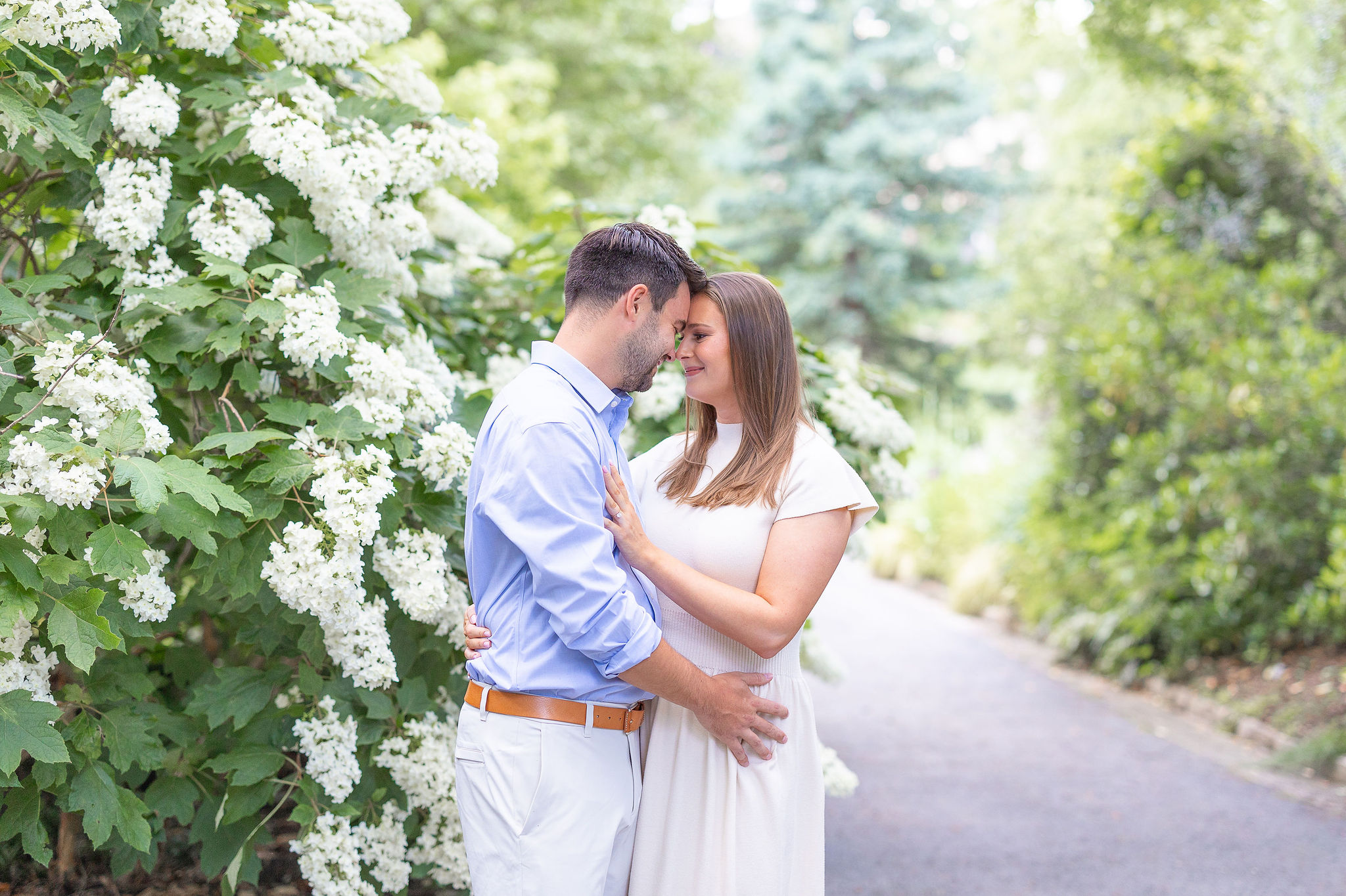 Couple in a garden with white flowers hugging