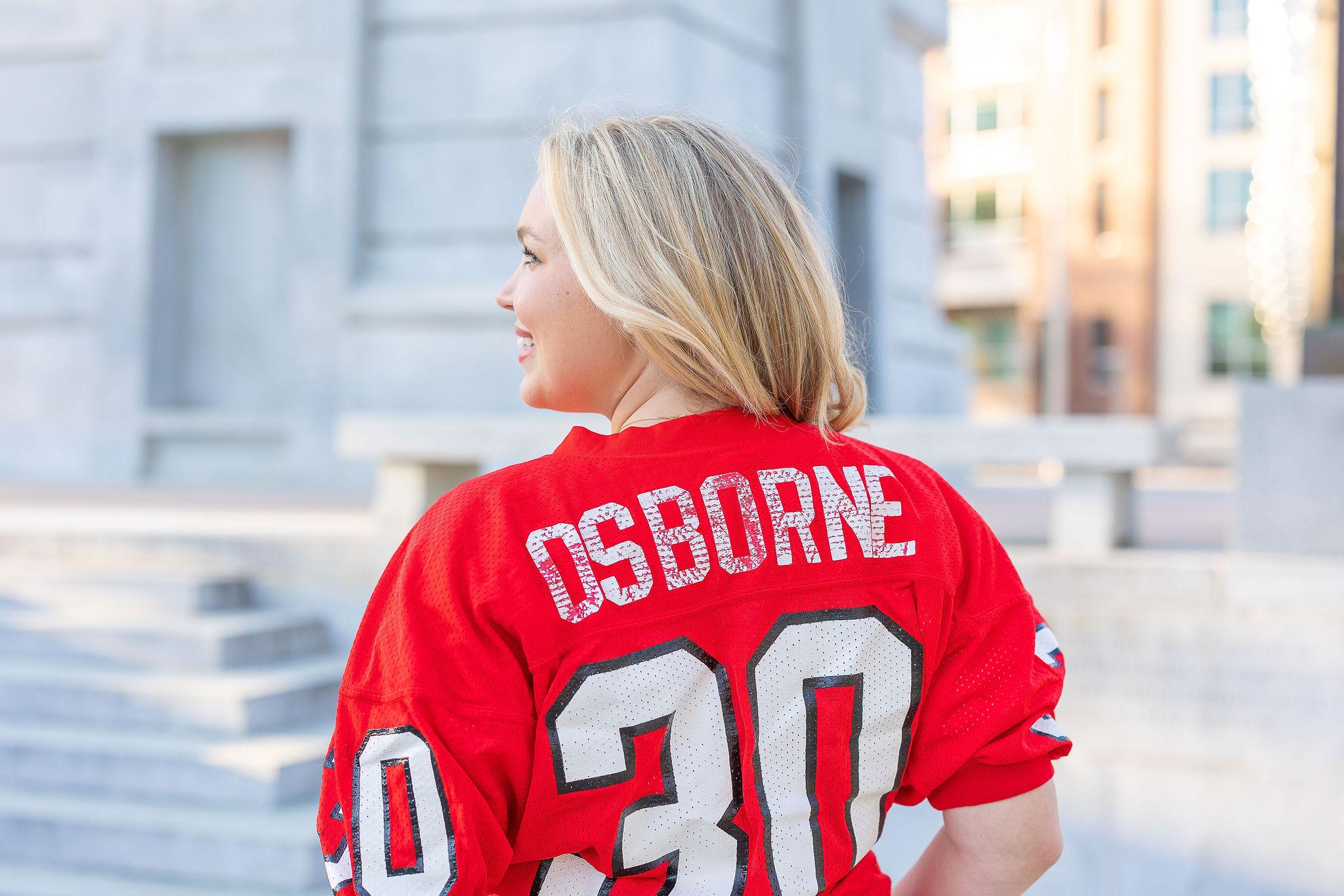 Girl wearing an NC State football jersey showing the back of it at the belltower