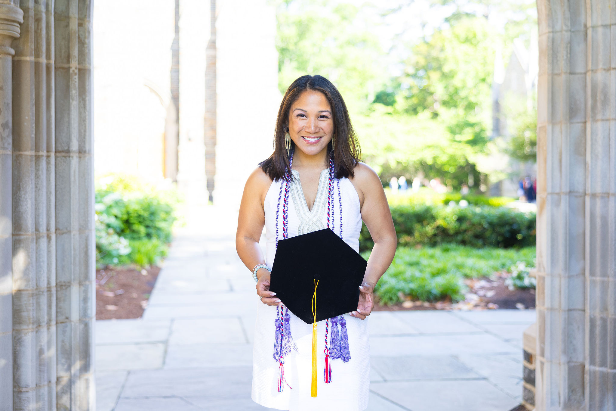 Duke University graduate girl in a white dress holding cap