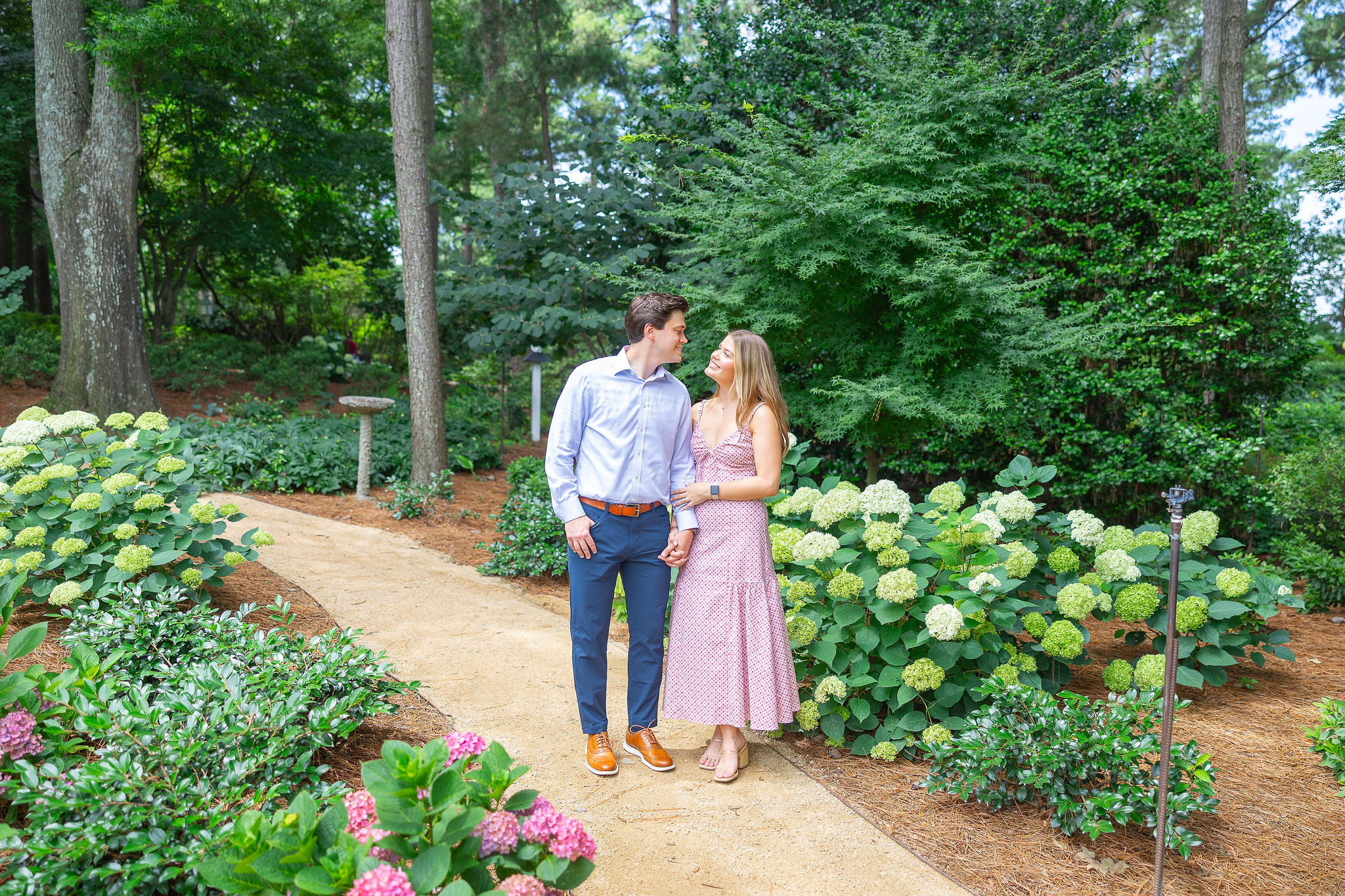 Couple holding each other walking in a garden
