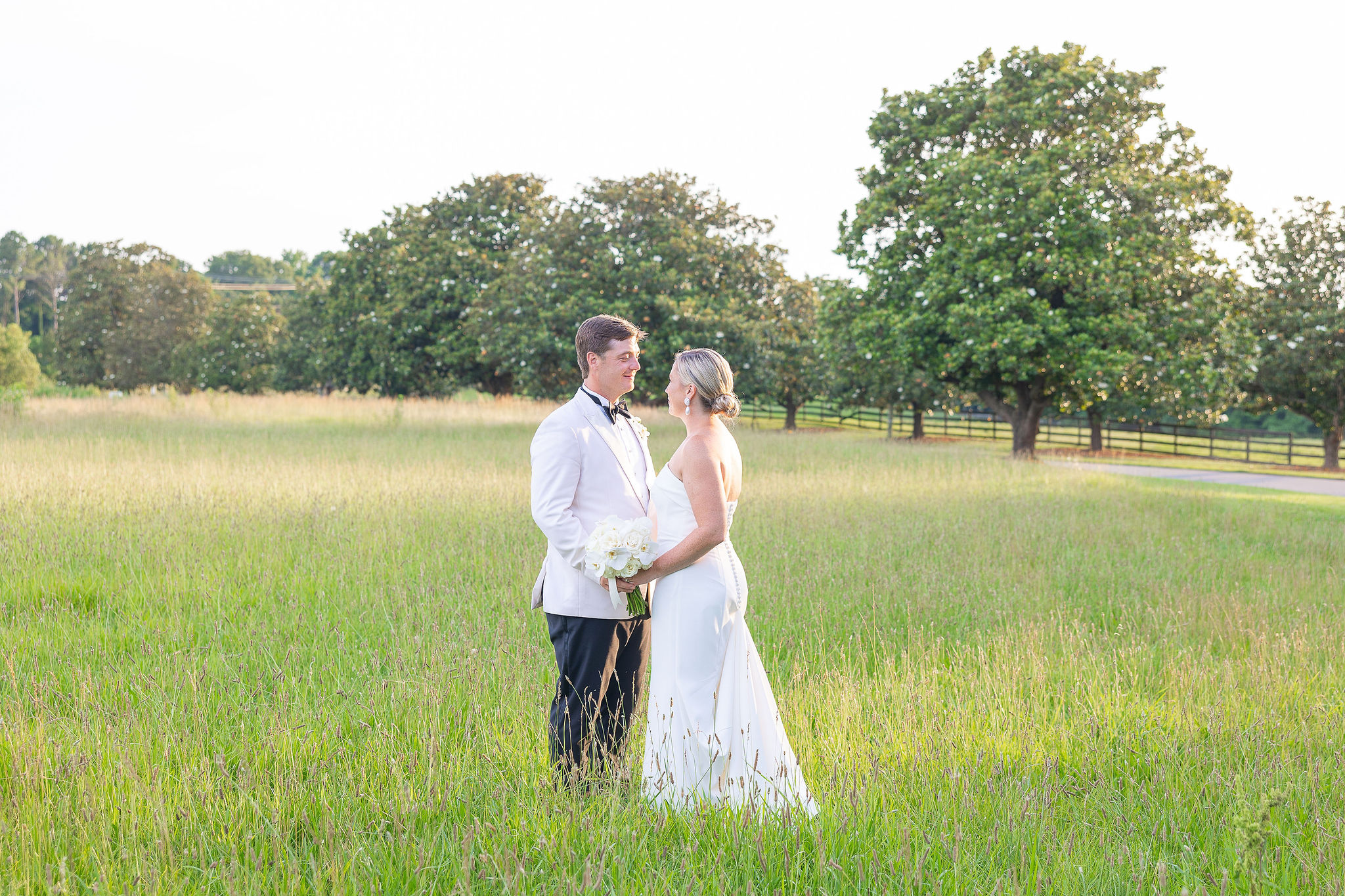 Couple in wedding attire in field