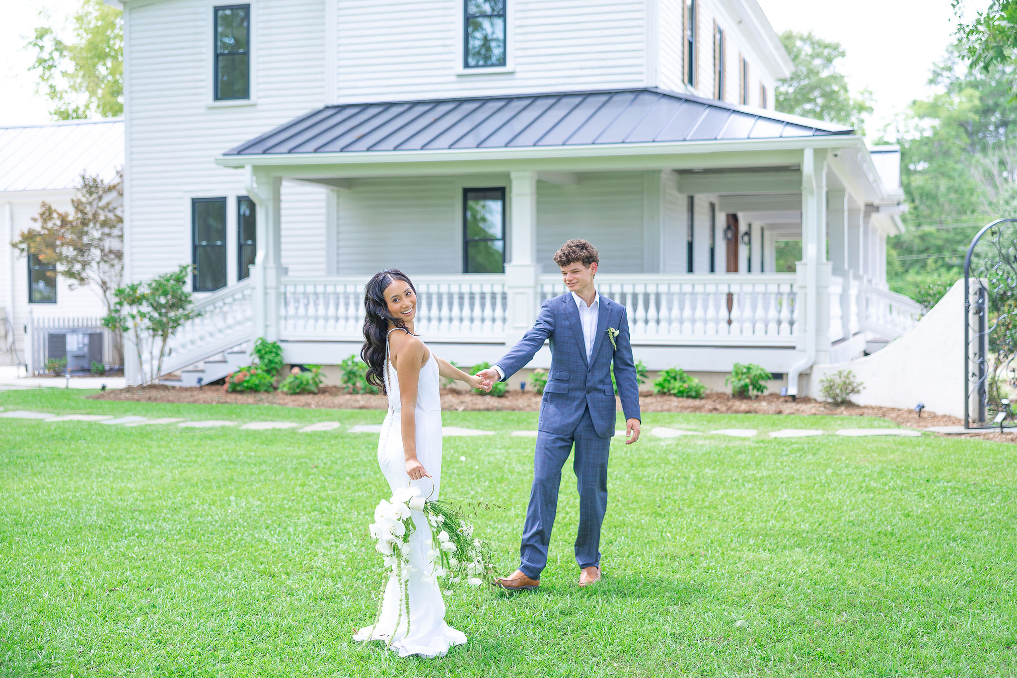 Bride and groom in front of wedding venue on lawn