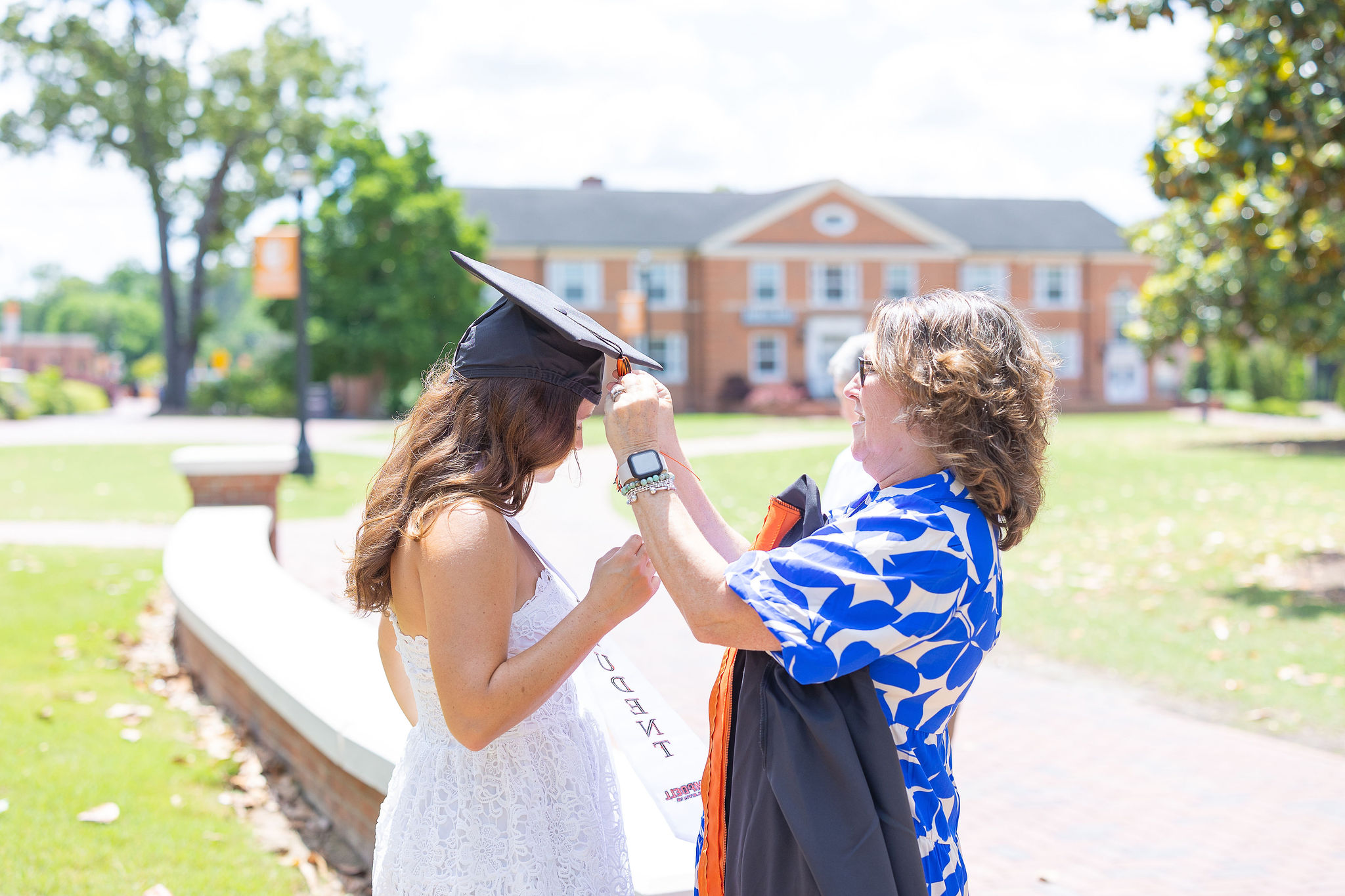 mom helping graduate put on cap at Campbell University