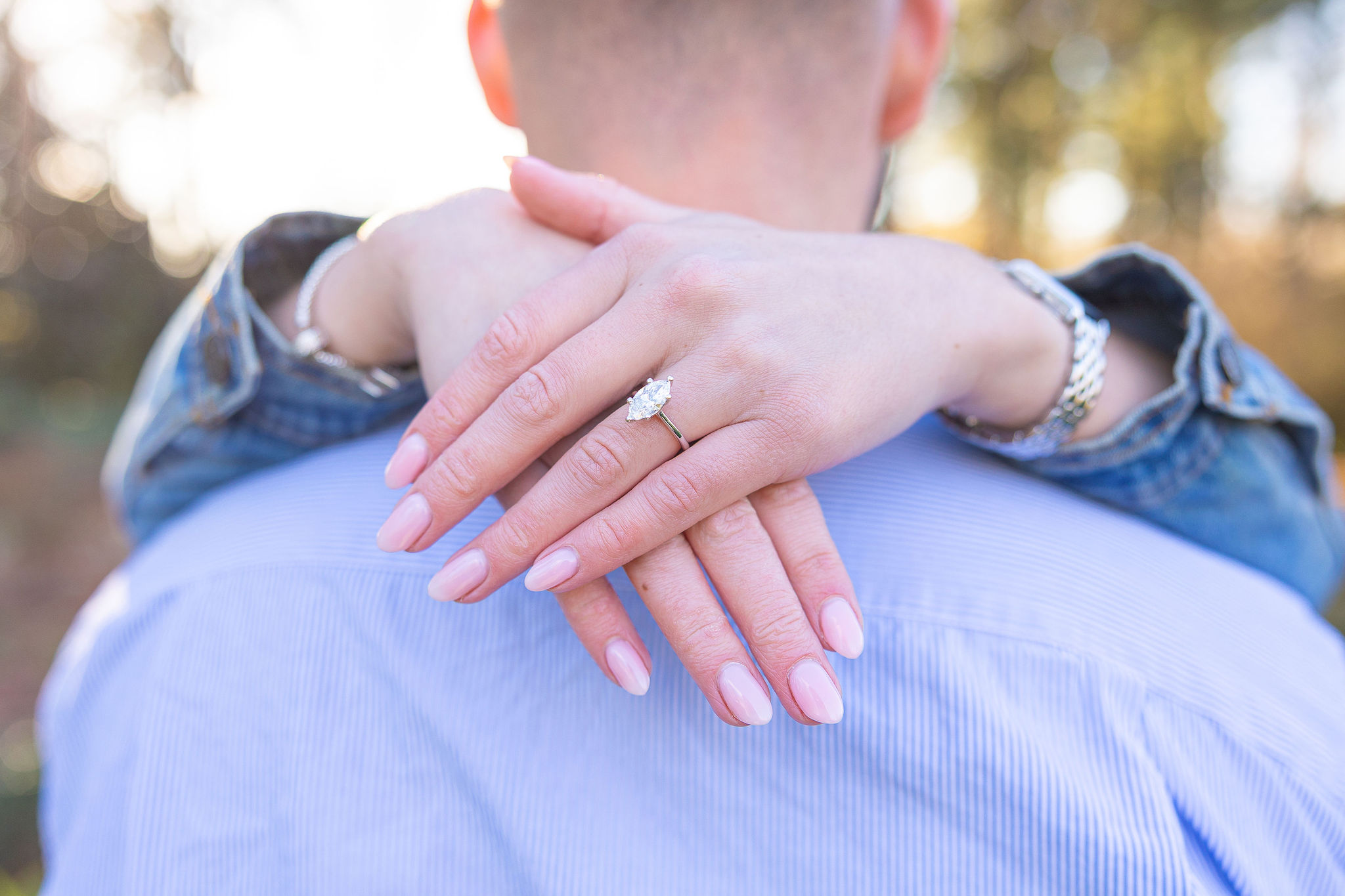 engagement ring close up photo wifes arm around husbands