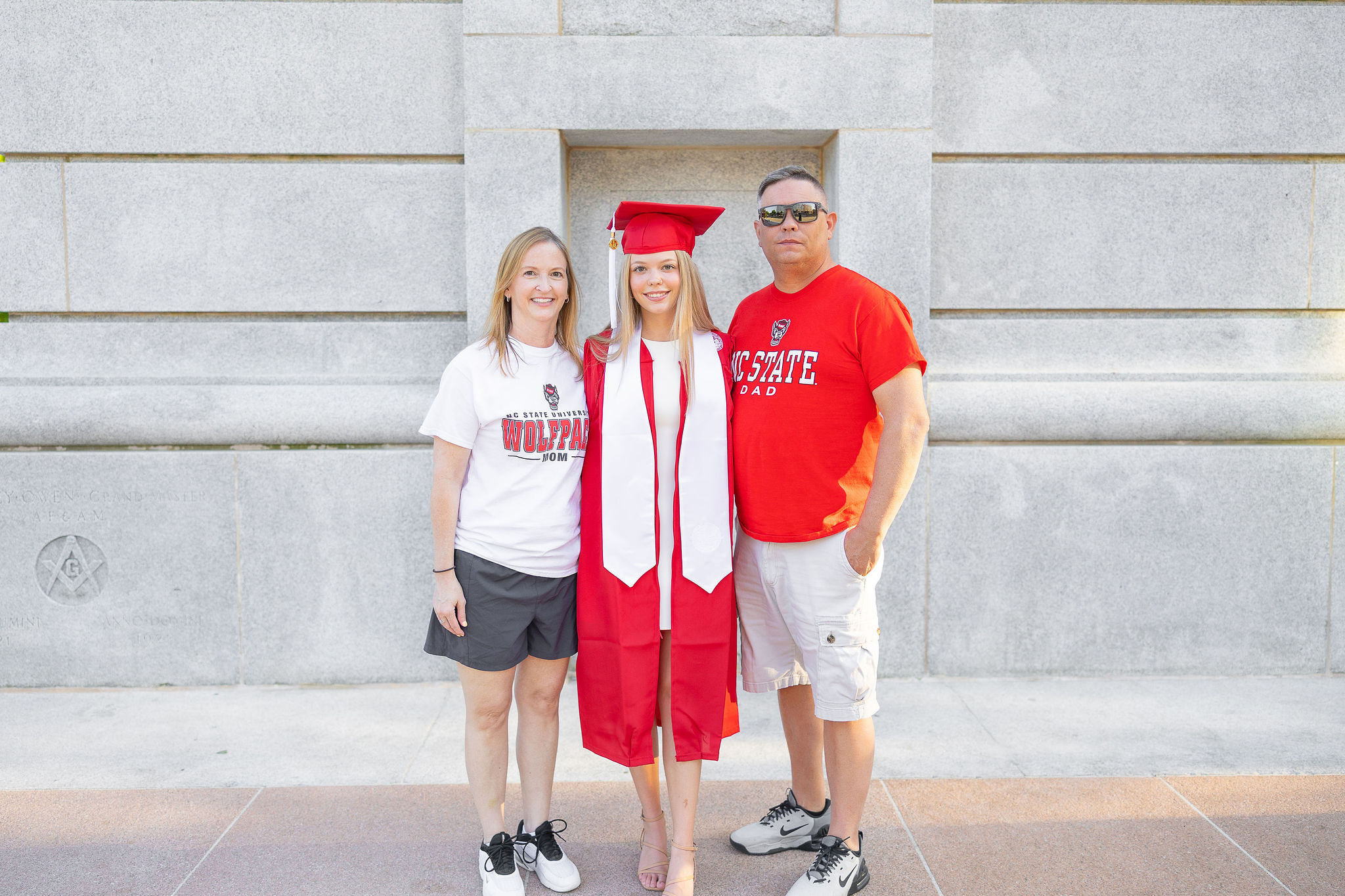 NC State Graduate with parents at belltower
