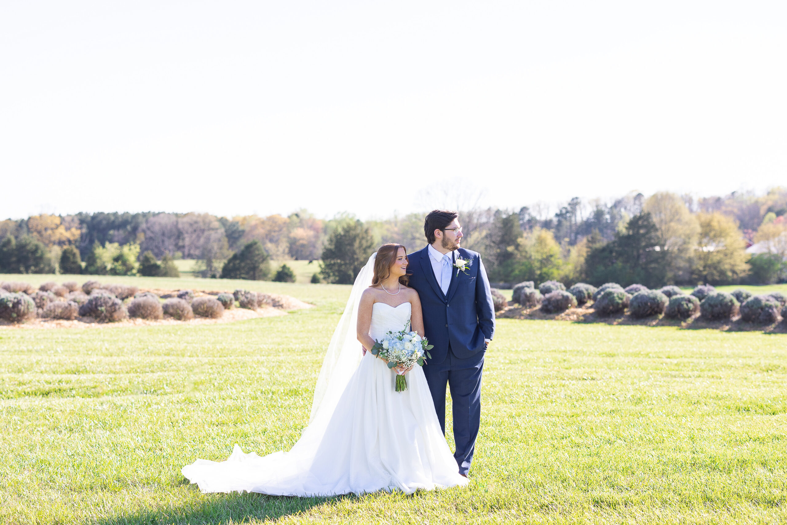 Bride and Groom in field looking to side
