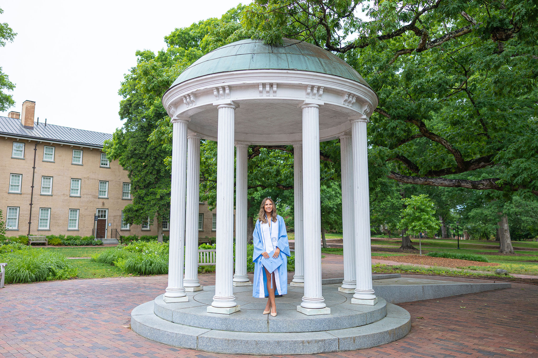 UNC Senior at Old Well in graduation gown