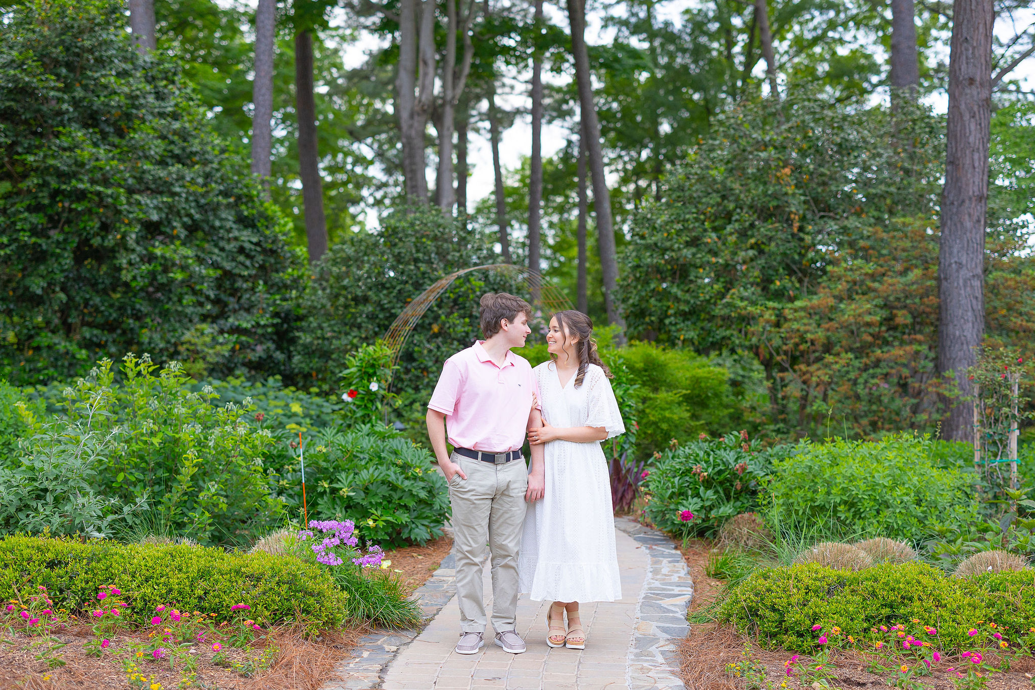 couple walking together down path at garden