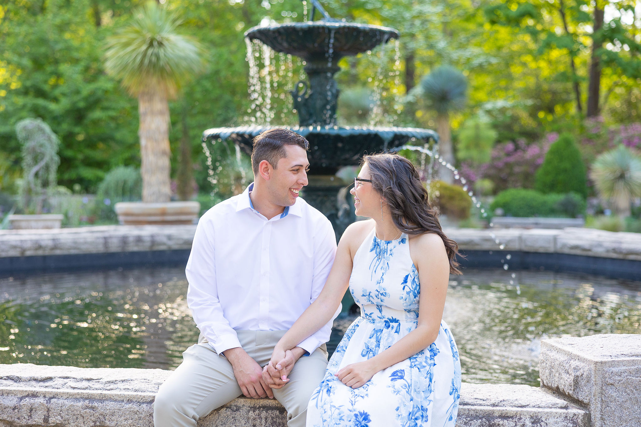 Couple sitting on bench near fountain of water
