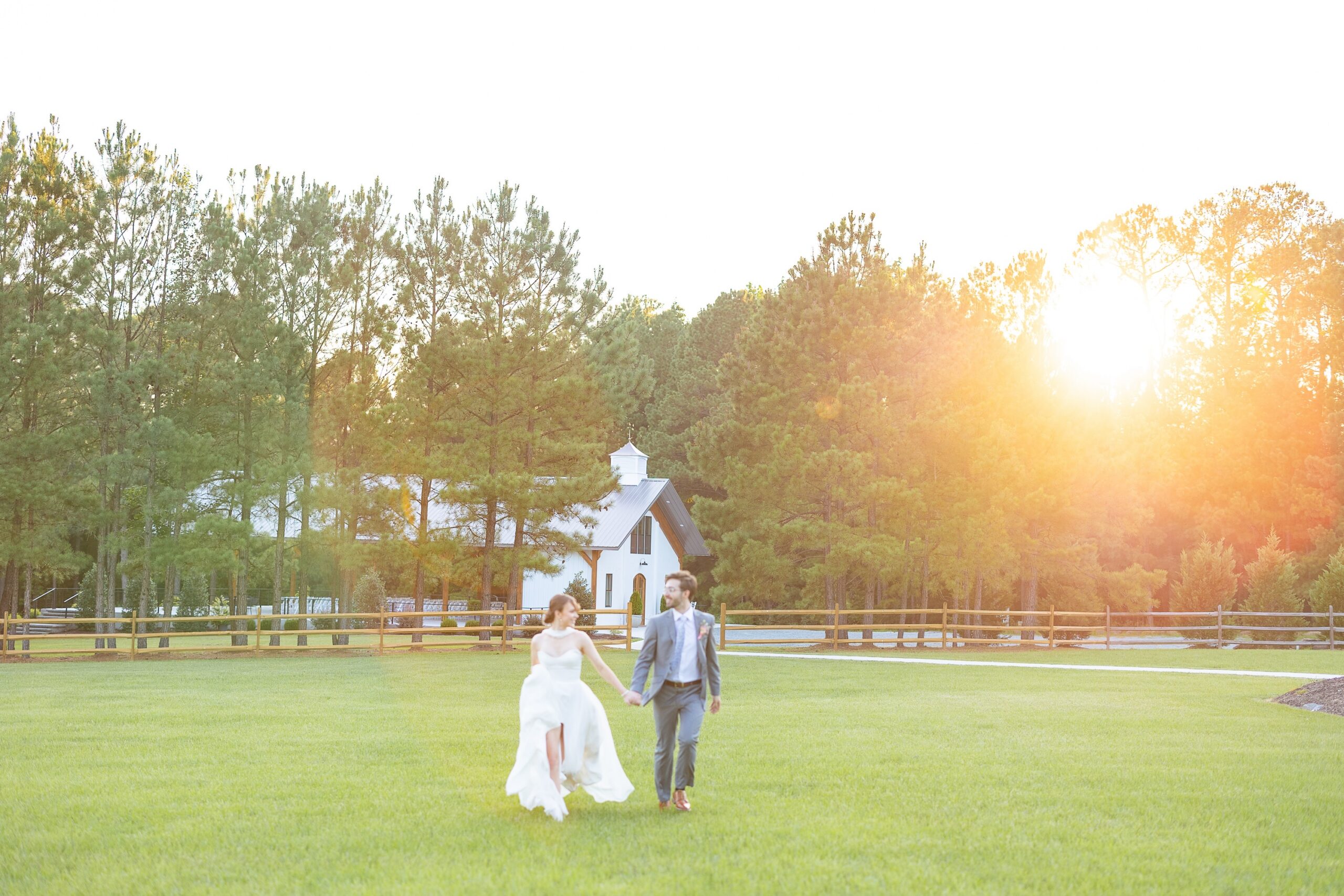 bride and groom at golden hour running through field