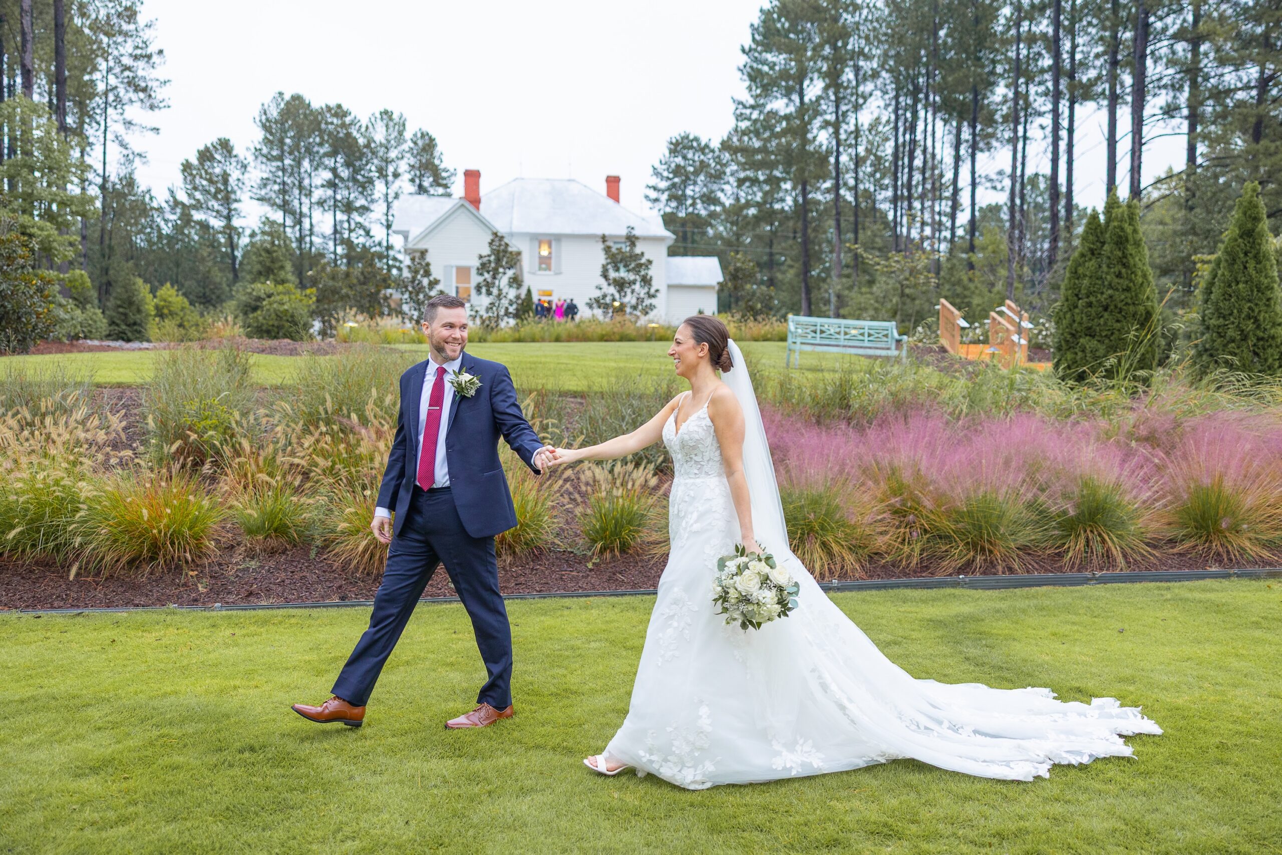 bride and groom walking on lawn holding hands